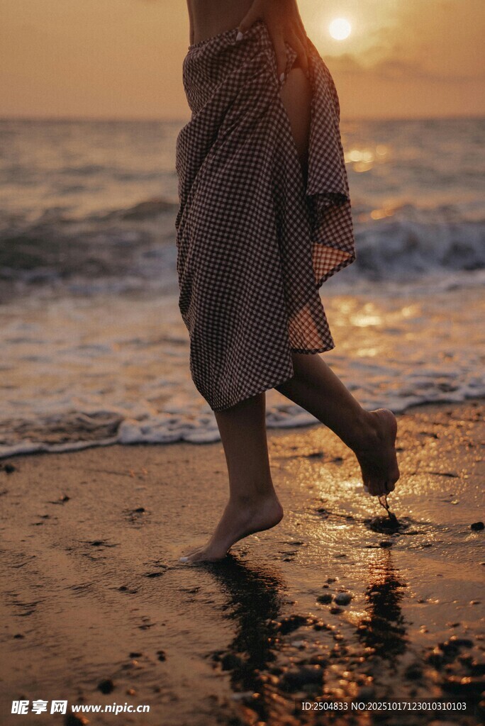 夕阳下漫步海滩的身影