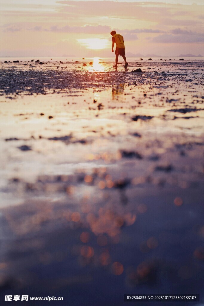 夕阳下海滩上的漫步身影
