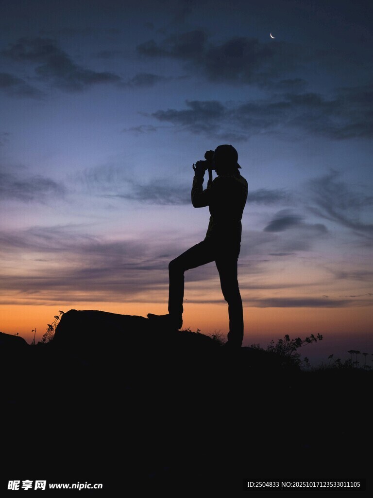 摄影师黄昏山顶拍摄剪影