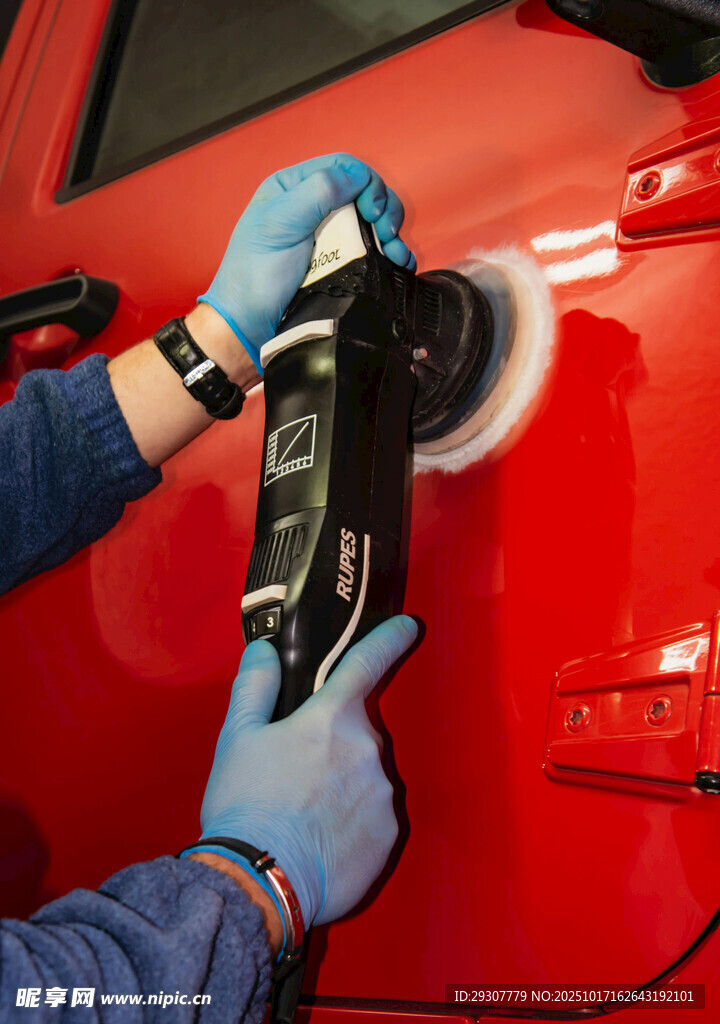 工人手持工具打磨红色汽车