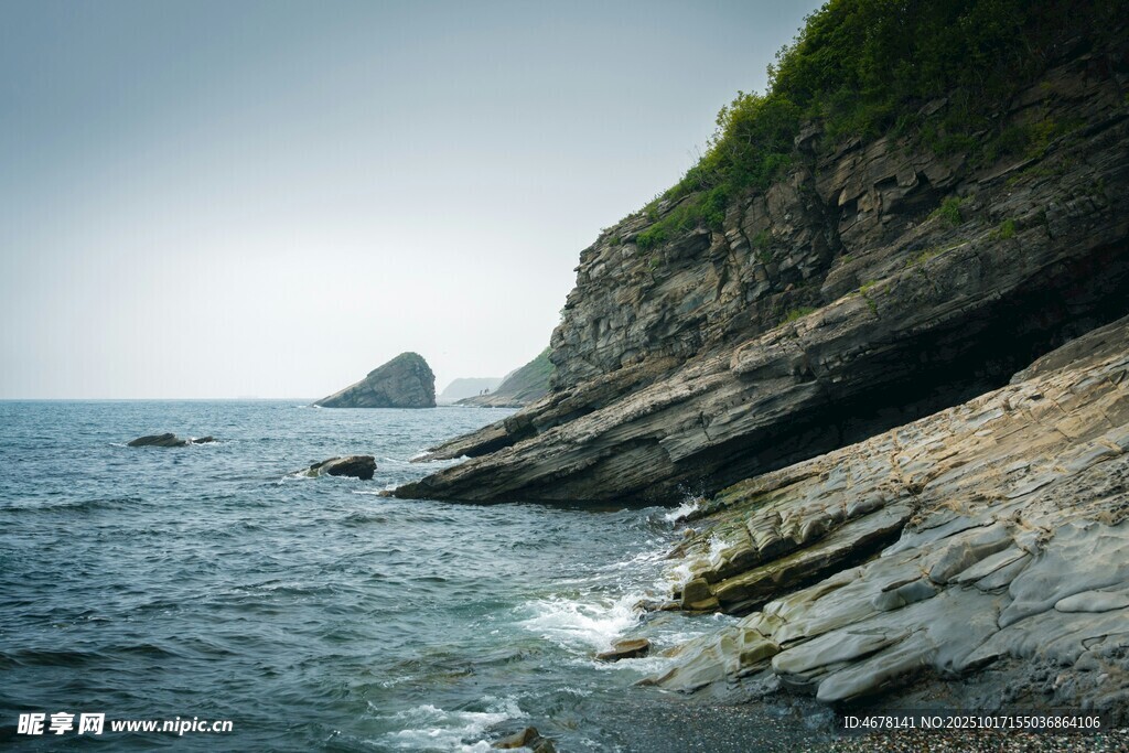 海岸嶙峋岩石与远处孤峰