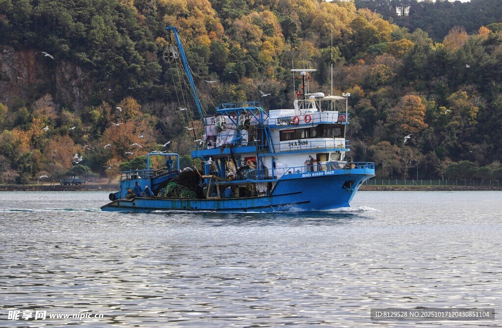 蓝色渔船行驶在山水间