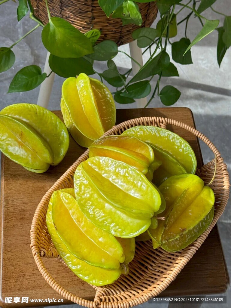 新鲜杨桃摆放在木盘与竹篮中