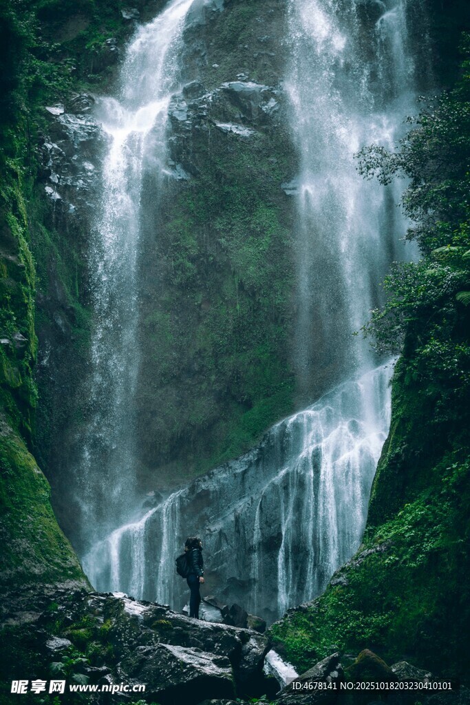 人立于壮观瀑布前赏景