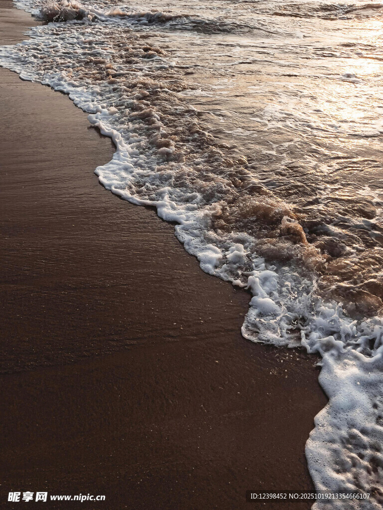 海边夕阳下的海浪拍打沙滩