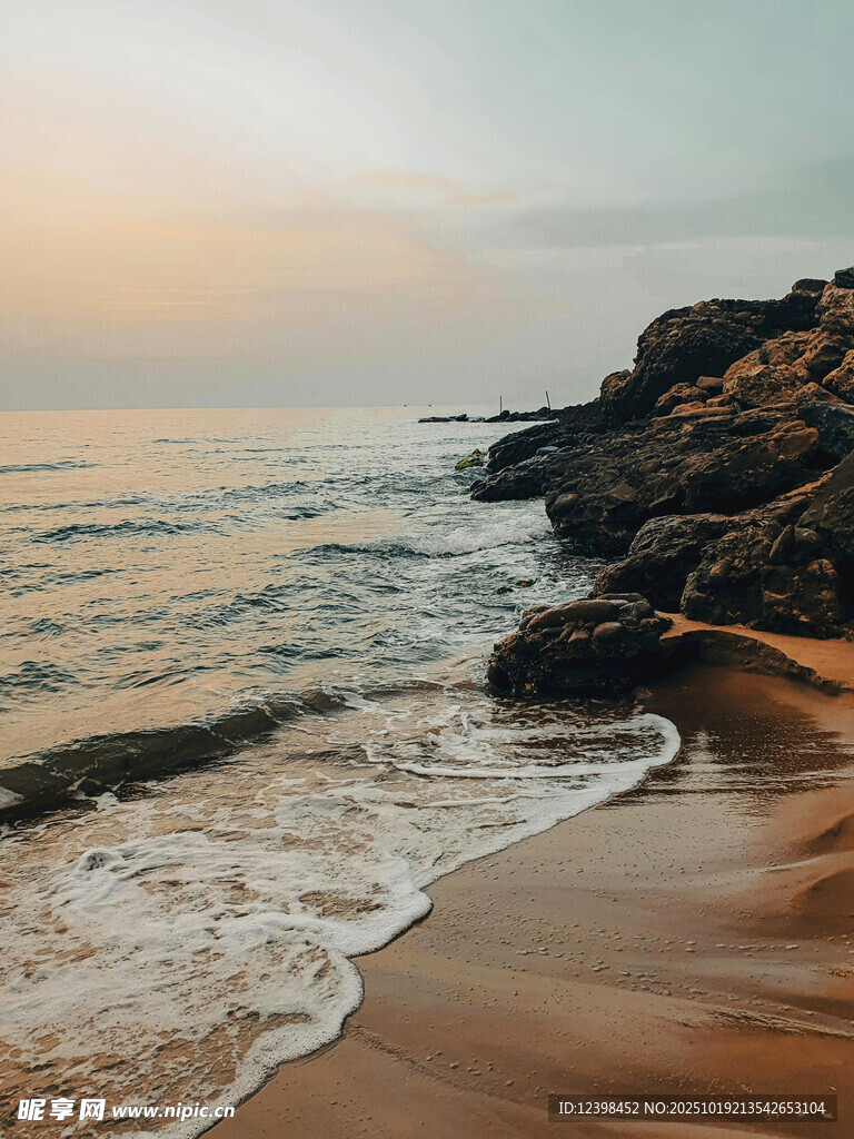 夕阳下的海边沙滩与礁石