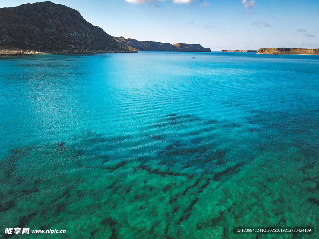 清澈蓝绿海水与远处山峦