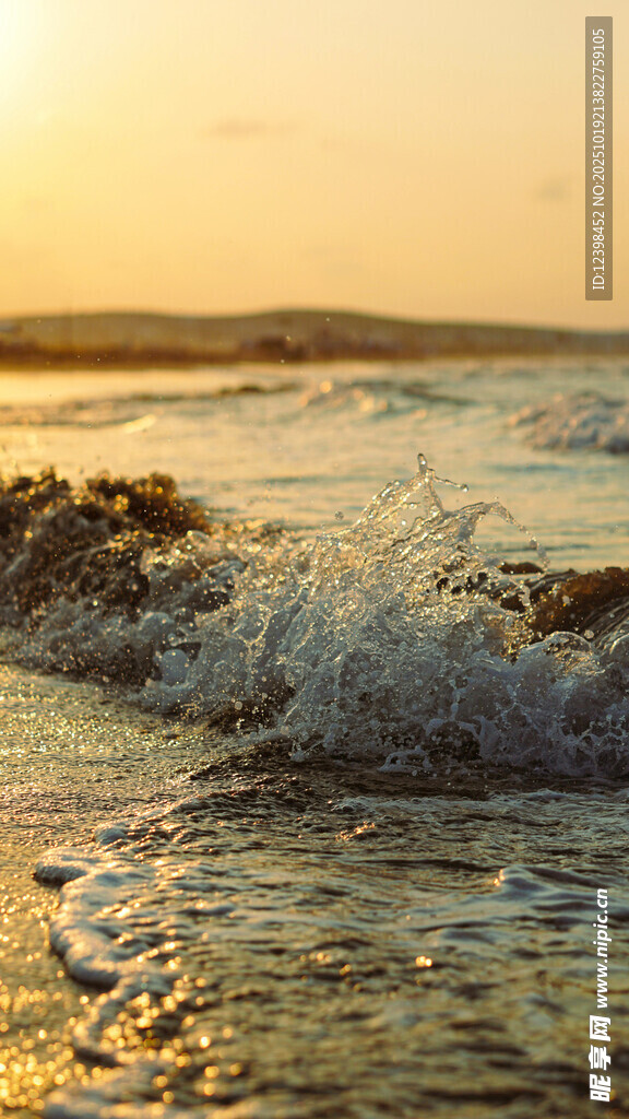 夕阳下的海浪拍打沙滩