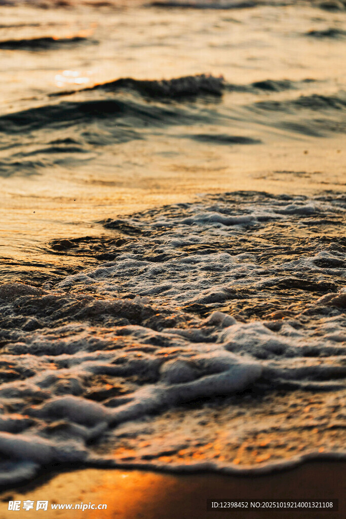 夕阳下的海浪拍打沙滩