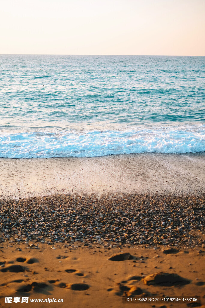 海边沙滩上的海浪与脚印