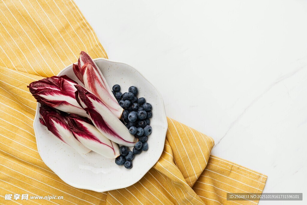 白盘上的菊苣与蓝莓