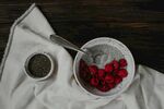 木桌白布上的树莓与茶叶