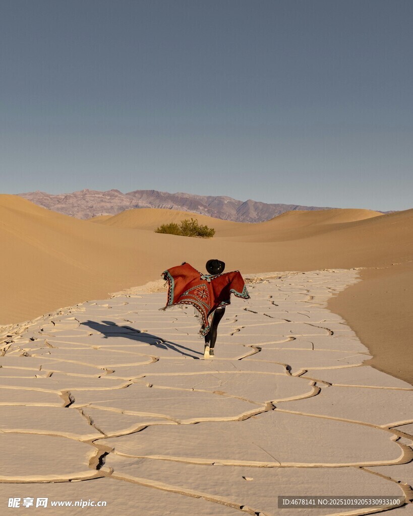 沙漠中持红布行走的旅人