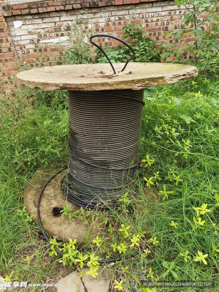 老旧电缆线圈置于草地间