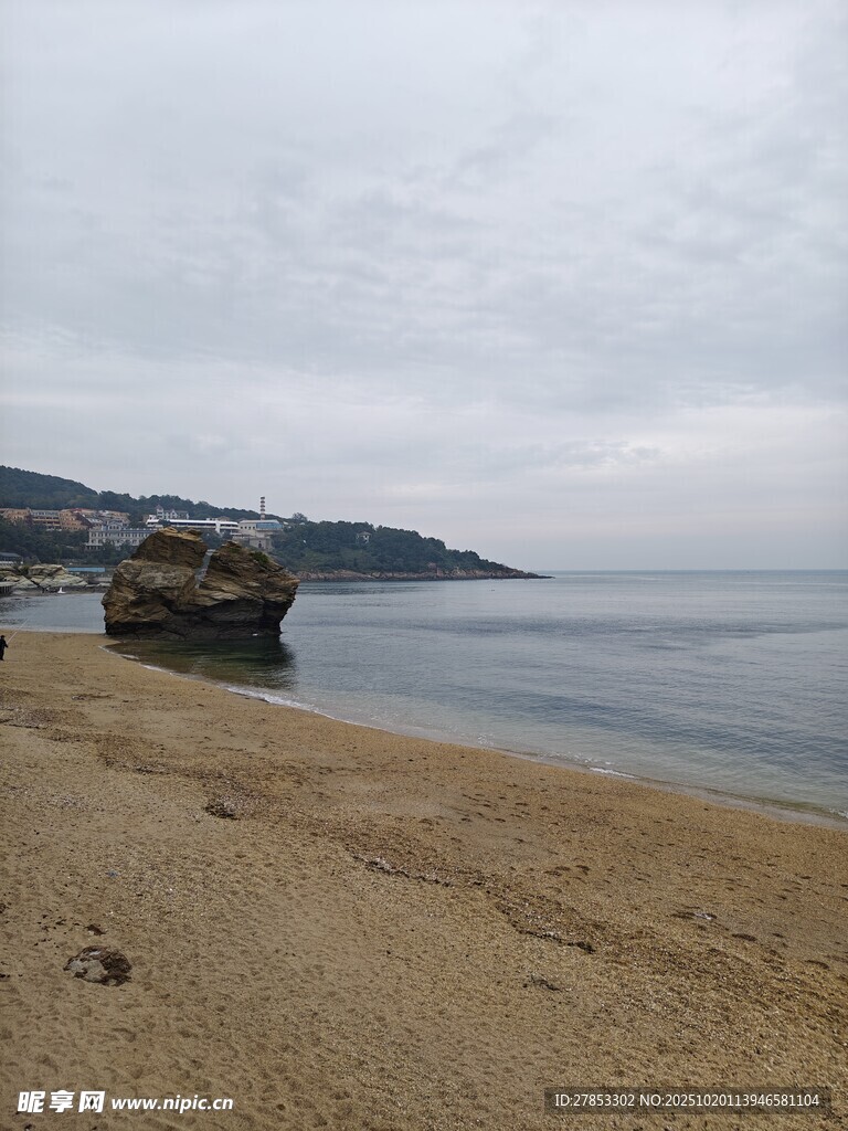 宁静沙滩与远处海崖景观