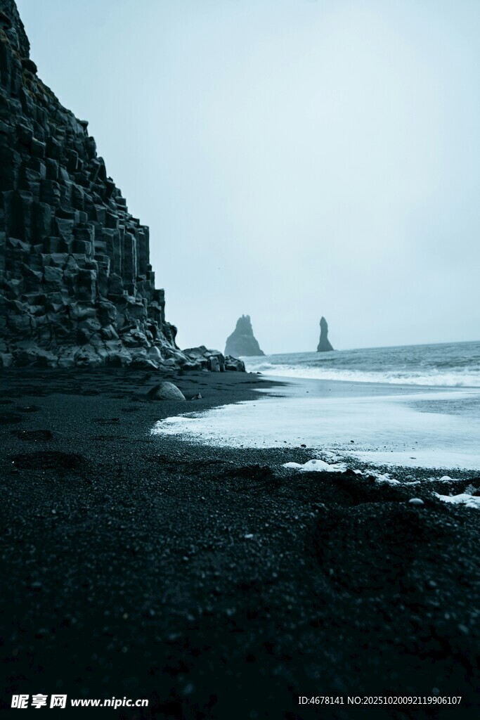 黑沙滩与远处海蚀柱景观