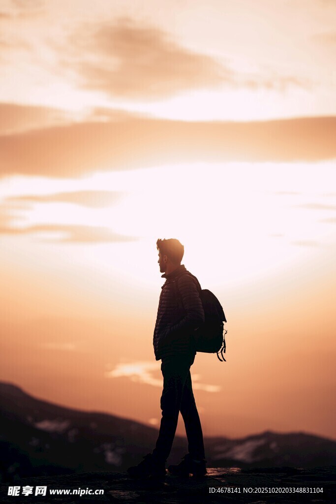 夕阳下徒步的背包旅人