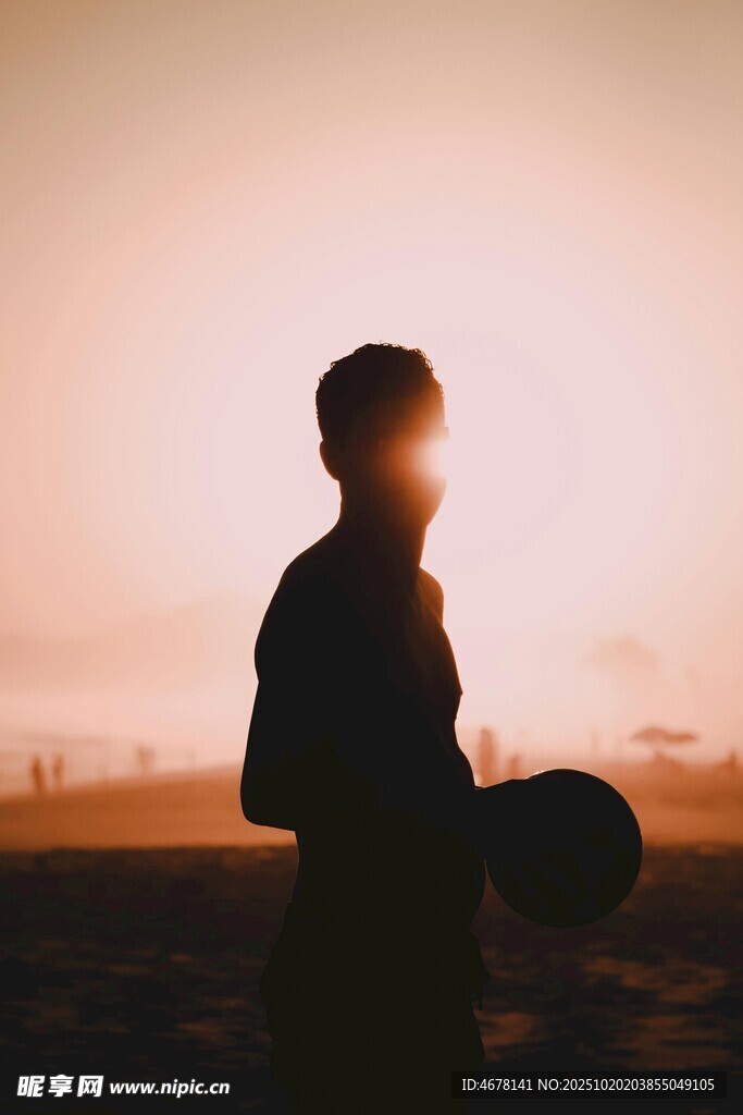 夕阳下的持帽男子剪影