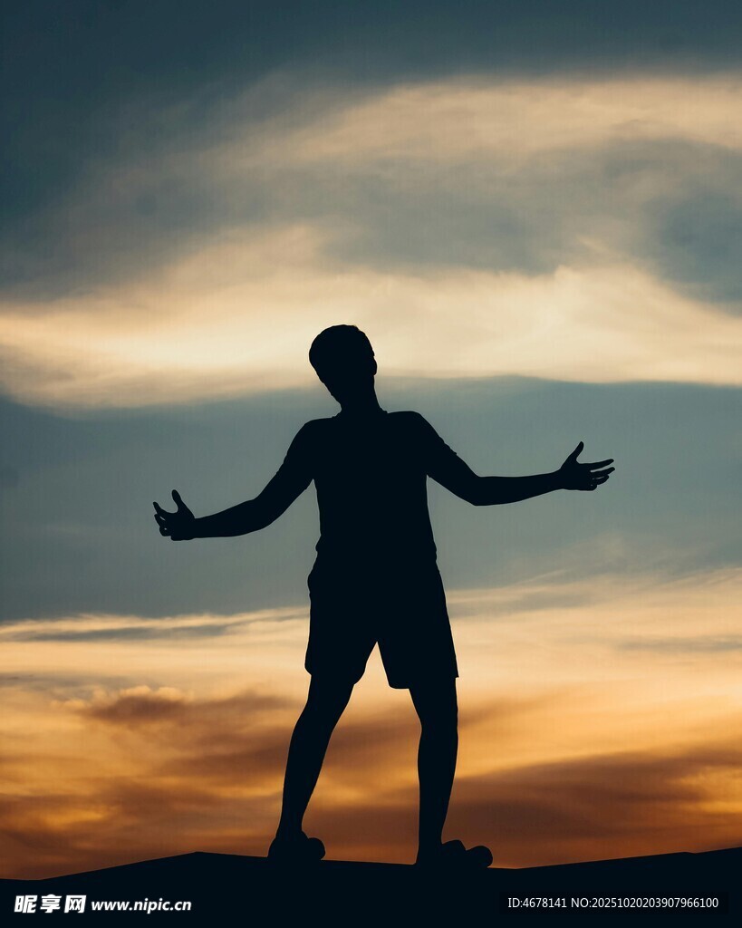 夕阳下张开双臂的人物剪影