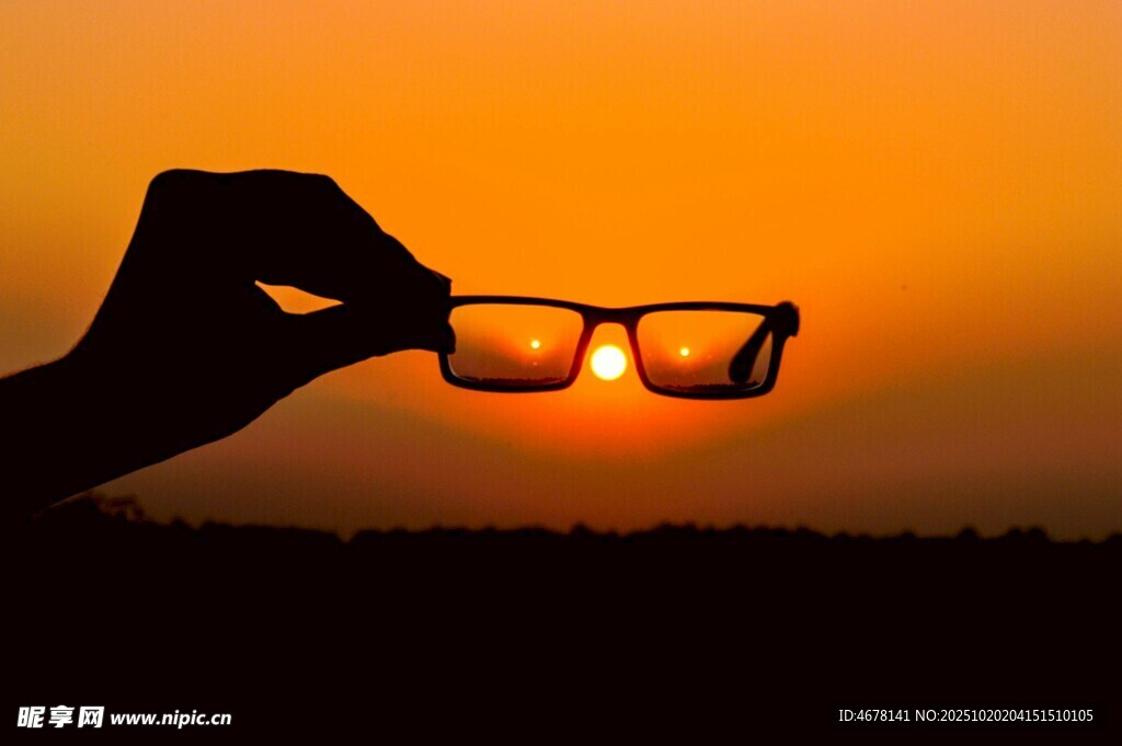 夕阳下手持眼镜的剪影