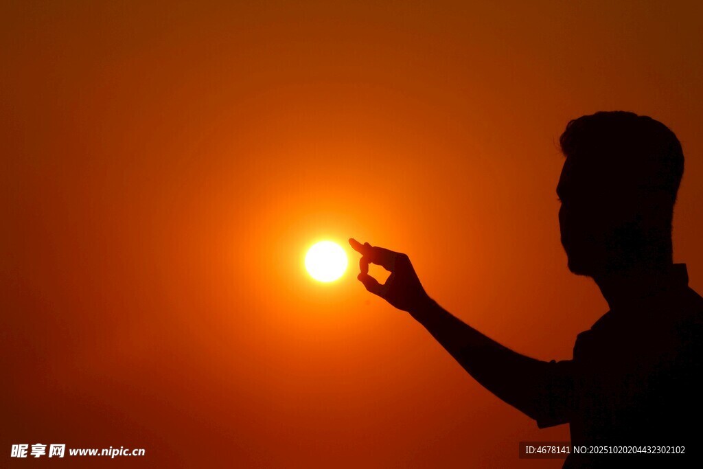 男子逆光捧握夕阳剪影