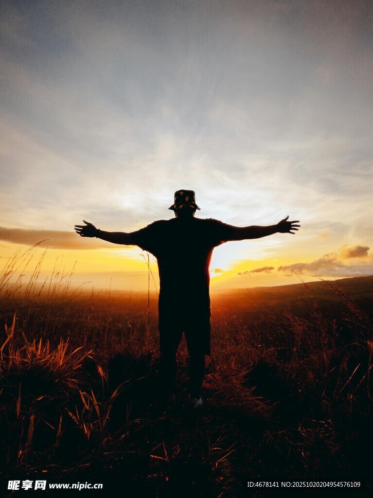 夕阳下张开双臂的人影