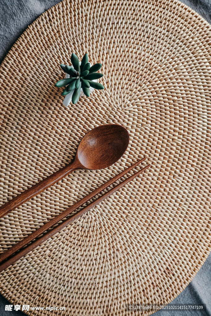 草编餐垫上的木餐具与绿植
