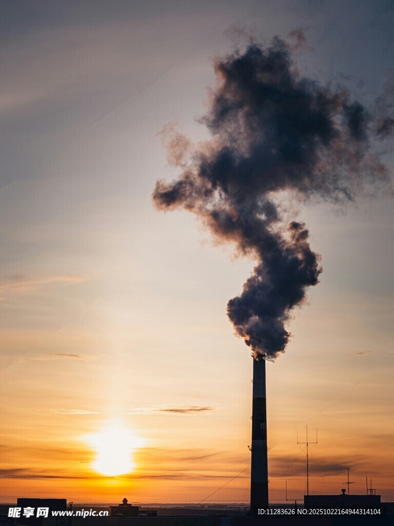 夕阳下工厂烟囱排放烟雾