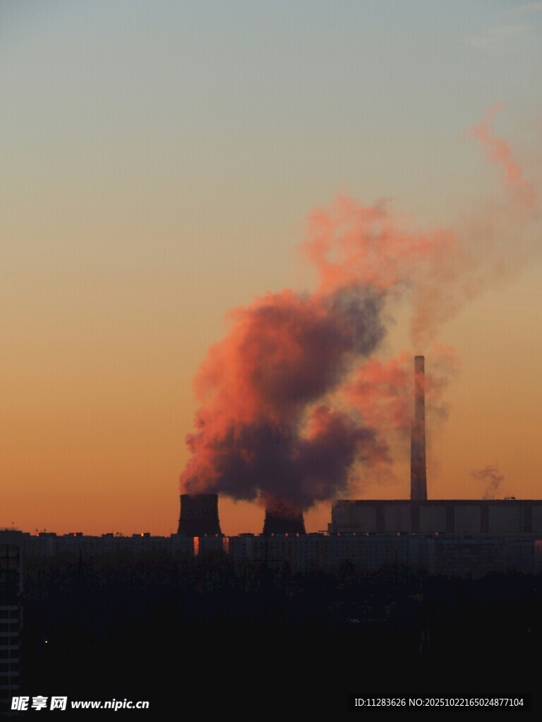 夕阳下的工厂烟囱冒烟景象