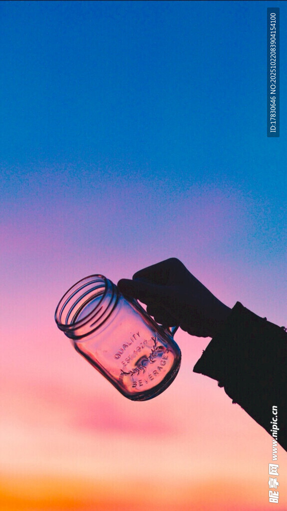 夕阳下手持透明玻璃杯