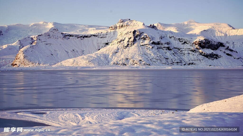 冰雪覆盖的山峦与平静湖面