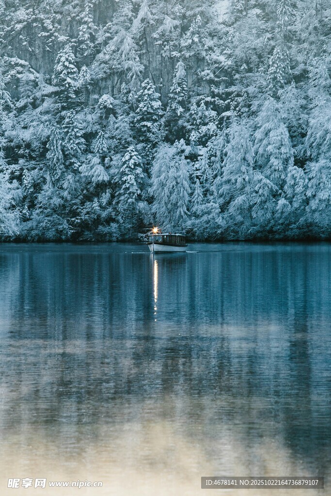 雪覆山林旁的静谧湖水