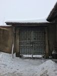 雪覆铁门的老旧院落一角