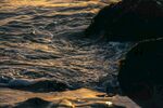 夕阳下海浪拍打礁石