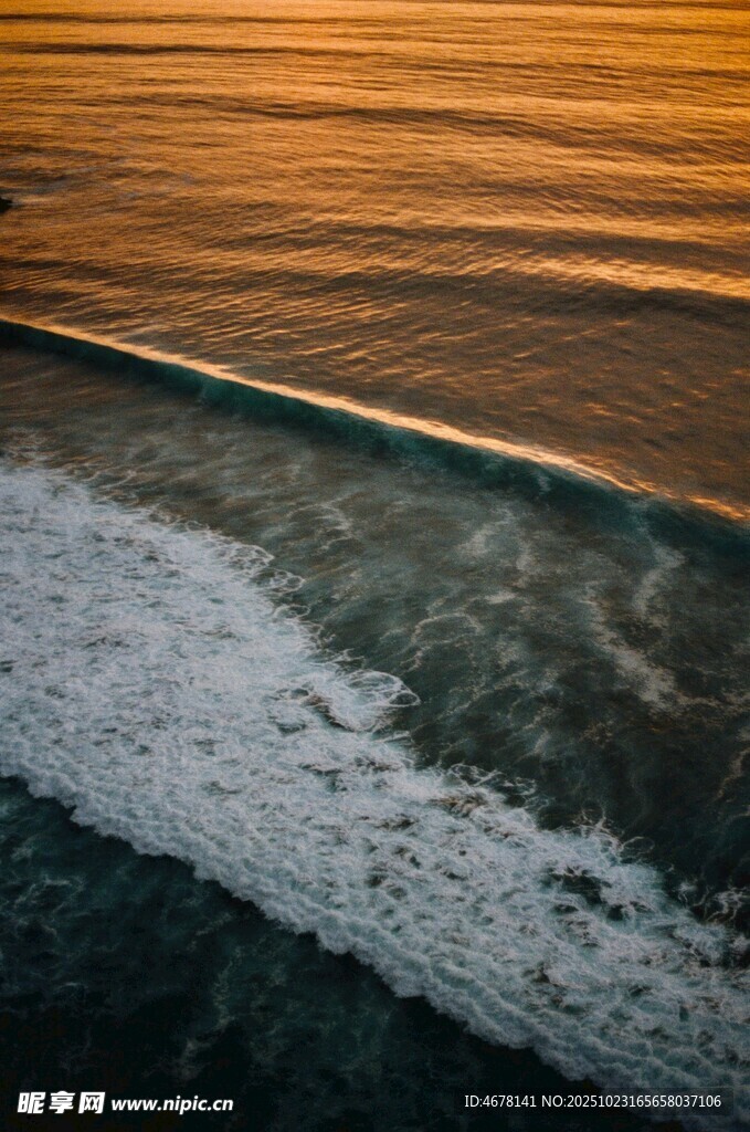 夕阳下的海浪拍打沙滩