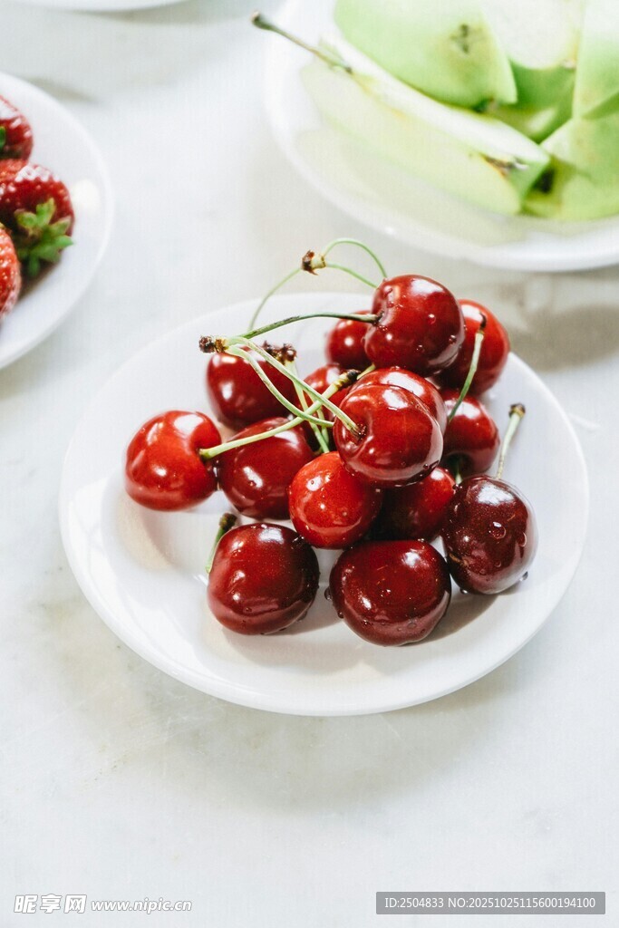 新鲜樱桃摆放在白色盘中