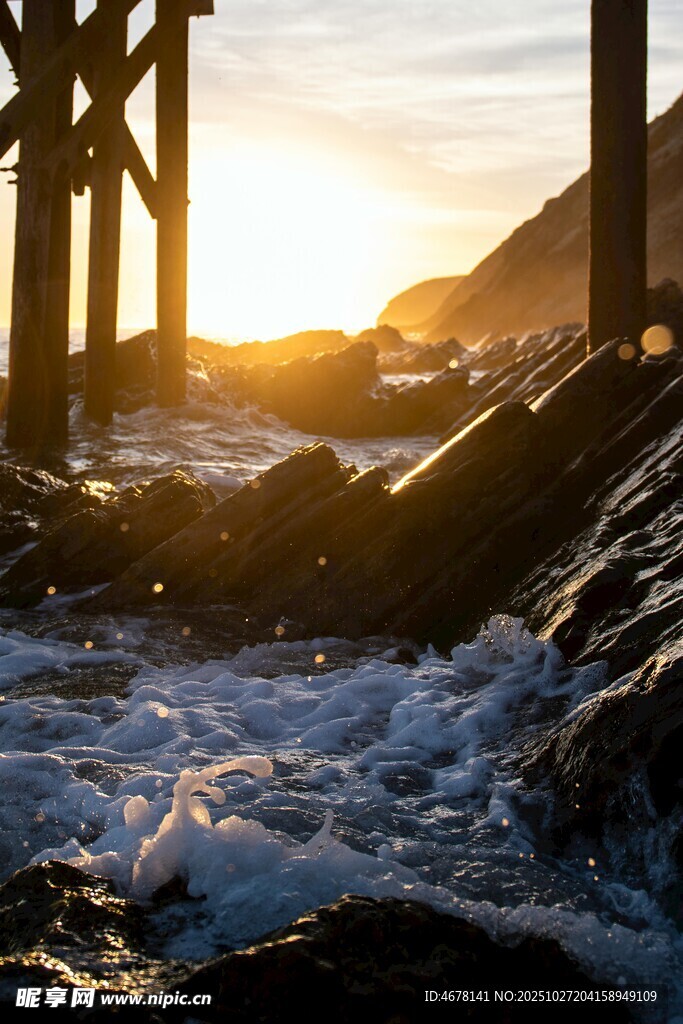 夕阳下海浪拍打栈桥场景