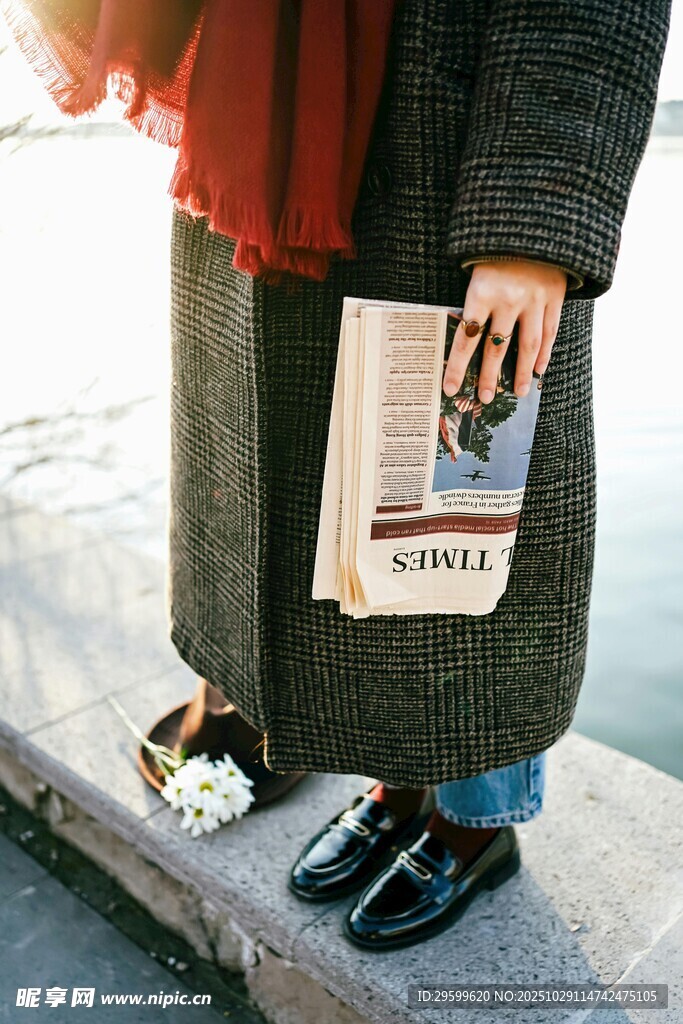 冬日街头手持报纸的时尚身影