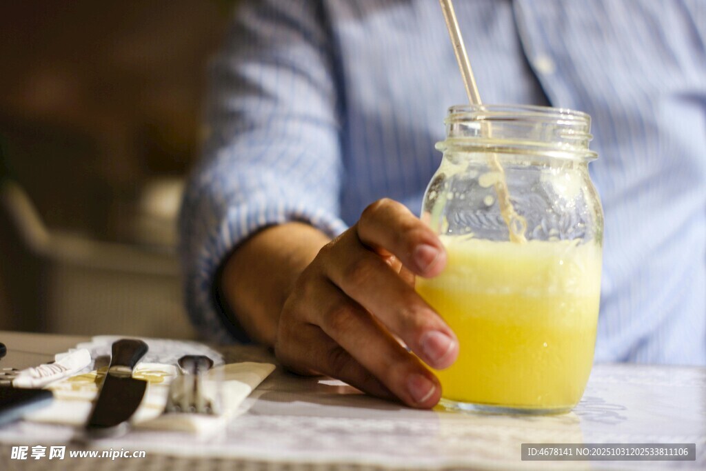 手持玻璃杯中的黄色饮品