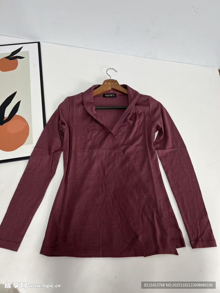 酒红色长袖上衣挂于墙前