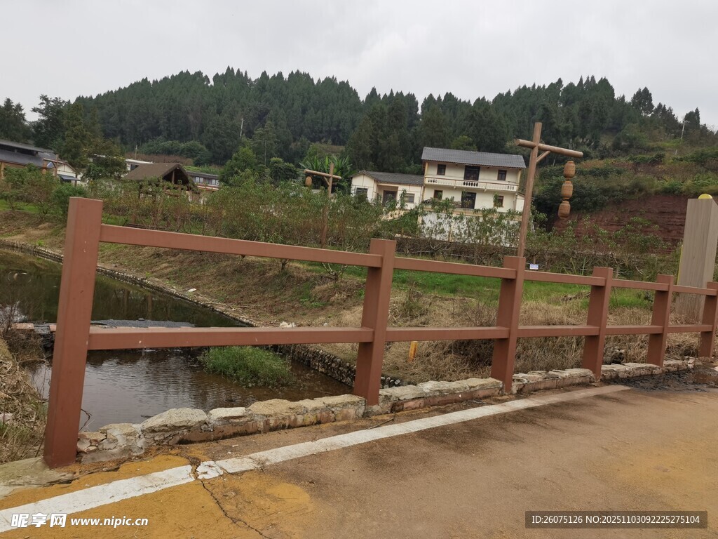 乡村路旁木栅栏与远处民居