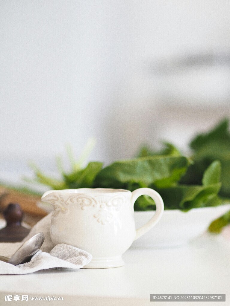 白色茶杯与新鲜绿叶