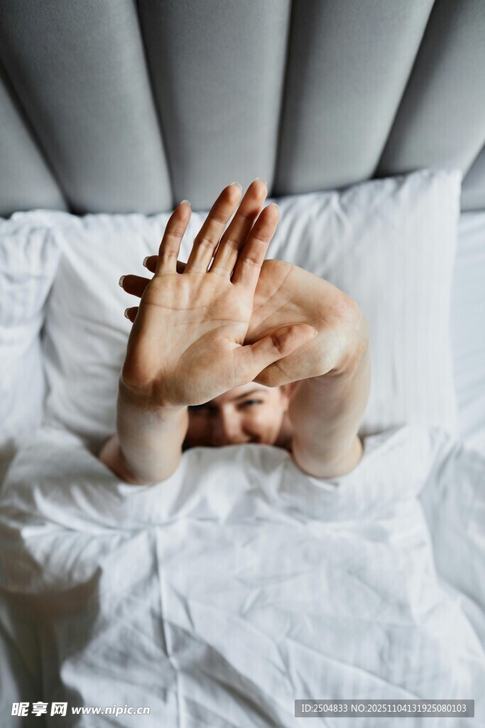 床上人用手遮挡面部