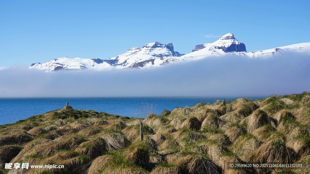 海边嶙峋岩石与远处雪山