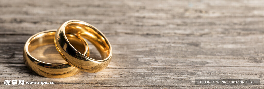 木质背景上的两枚金戒指