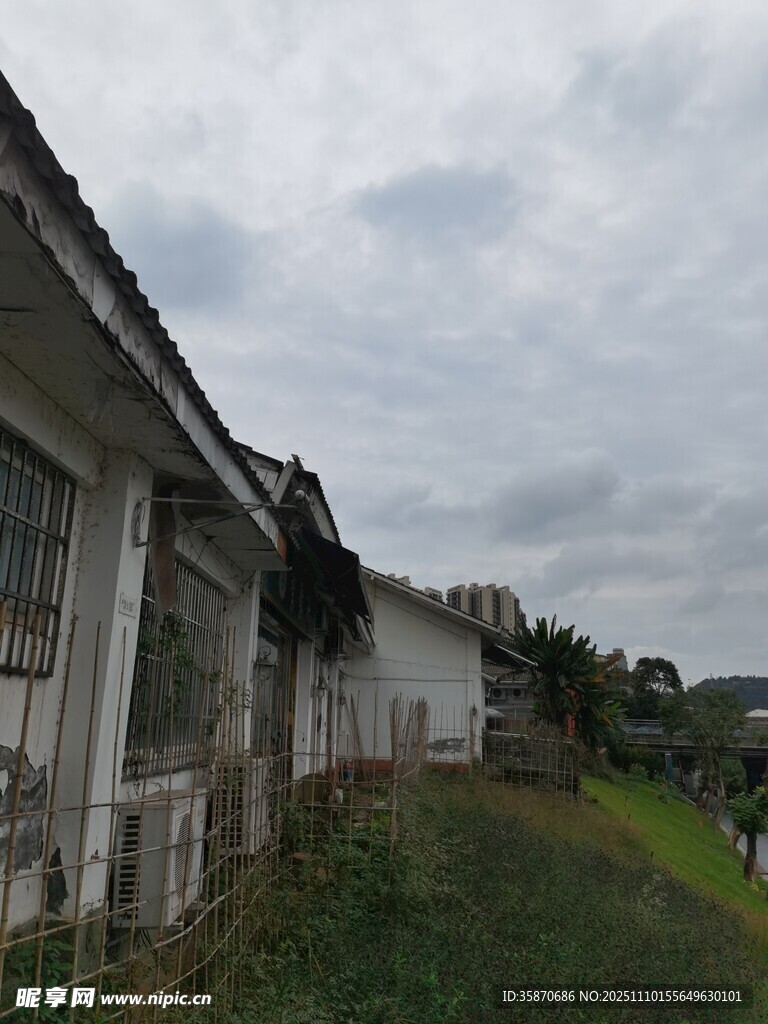 老旧房屋旁的草地与天空