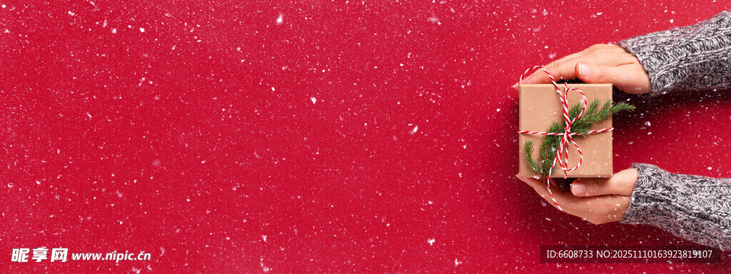 双手捧礼物于红背景前