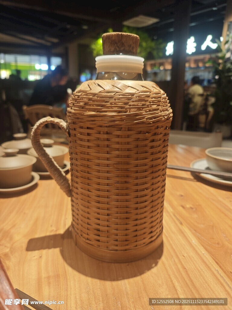 藤编暖瓶置于木桌之上