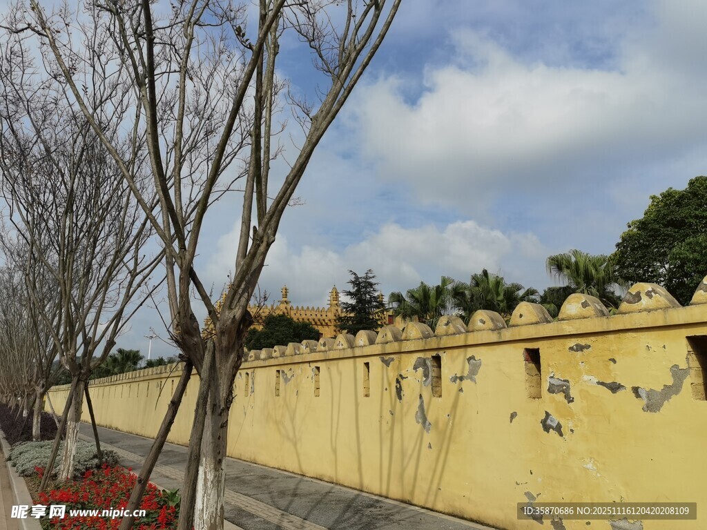 古老黄墙与蓝天绿树相映