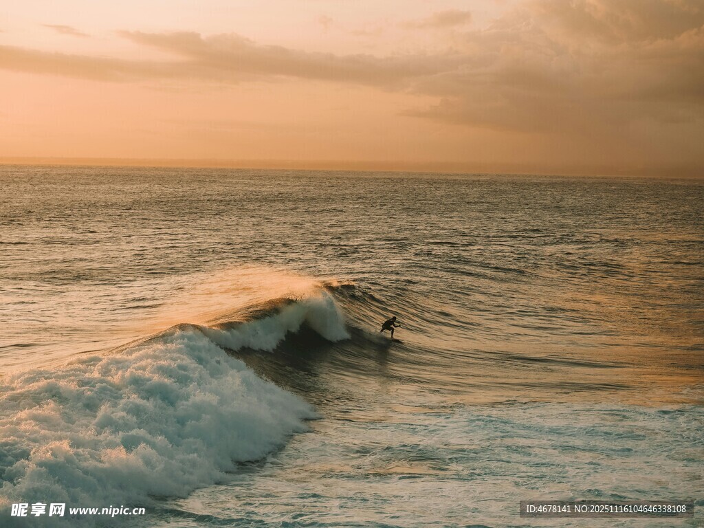 夕阳下冲浪者踏浪前行